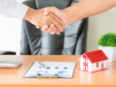 Side view hands of agent and client shaking hands after signed contract buy new apartment.